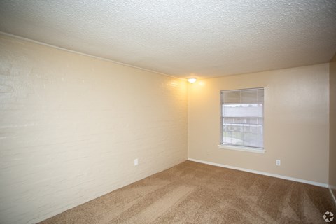 the interior of a bedroom with carpet and a window